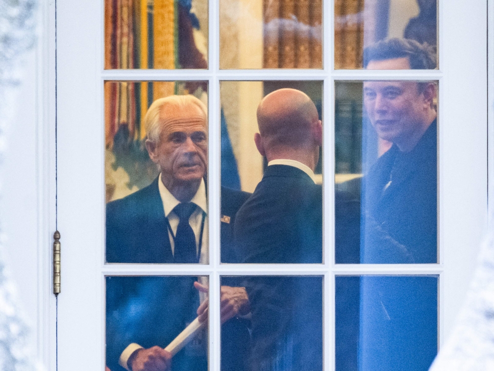 (Files) (L-R) Senior Counselor to the President for Trade and Manufacturing, Peter Navarro, White House deputy chief of staff for policy and US homeland security advisor Stephen Miller, and Elon Musk speak inside the Oval Office of the White House on March 14, 2025. (Photo by Roberto Schmidt / AFP)
