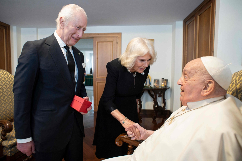 This photo taken on April 9, 2025 and handout on April 10, 2025 by The Vatican Media shows Pope Francis during a private meeting with Britain's King Charles III and Queen Camilla in The Vatican. (Photo by Handout / Vatican Media / AFP) 