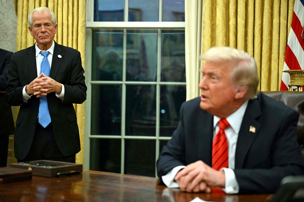 US President Donald Trump speaks to the press, alongside counselor to US President Donald Trump, Peter Navarro (L), after signing an executive order in the Oval Office of the White House in Washington, DC, on February 10, 2025. Photo by ANDREW CABALLERO-REYNOLDS / AFP