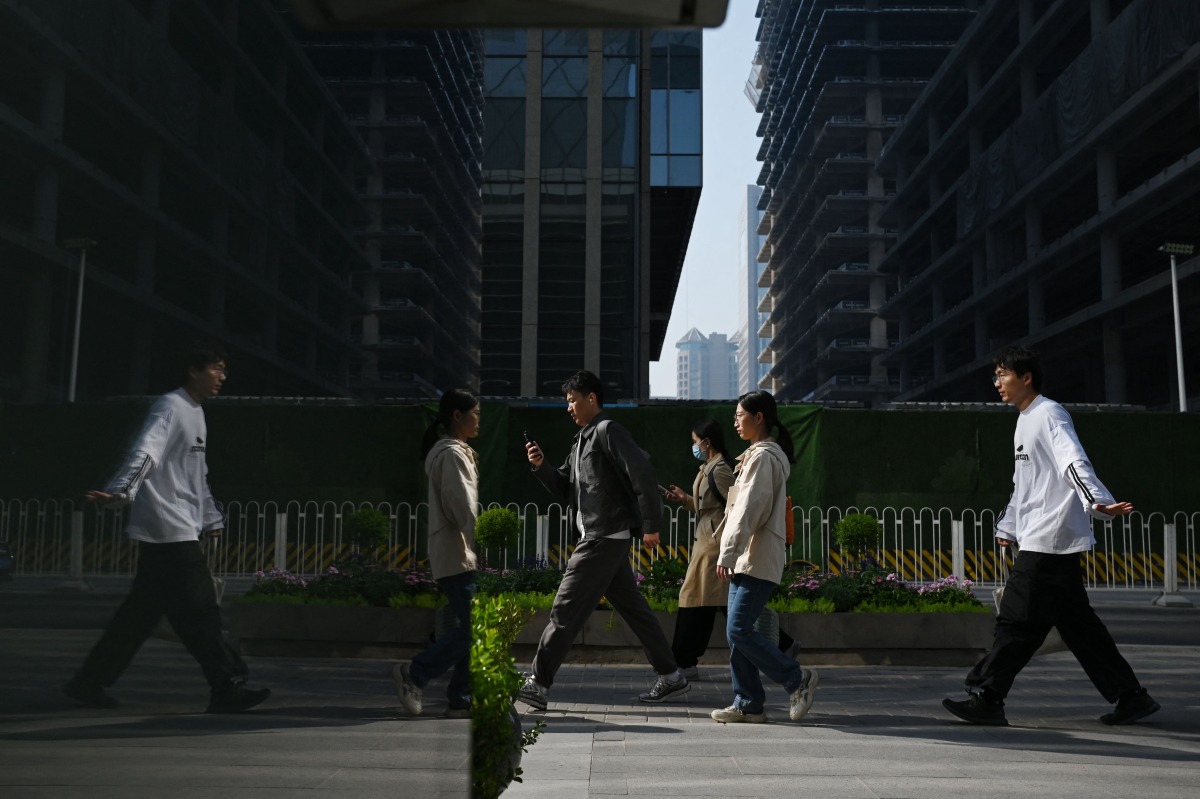 Office workers walk to their offices in Beijing's central business district on April 10, 2025. Photo by GREG BAKER / AFP