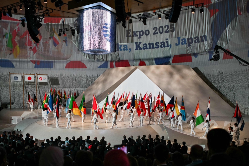 Performers parade participating countries' flags during the official opening ceremony of the 2025 Osaka Expo in the city of Osaka on April 12, 2025, a day before the event opens to the public for six months. (Photo by Philip Fong / AFP)