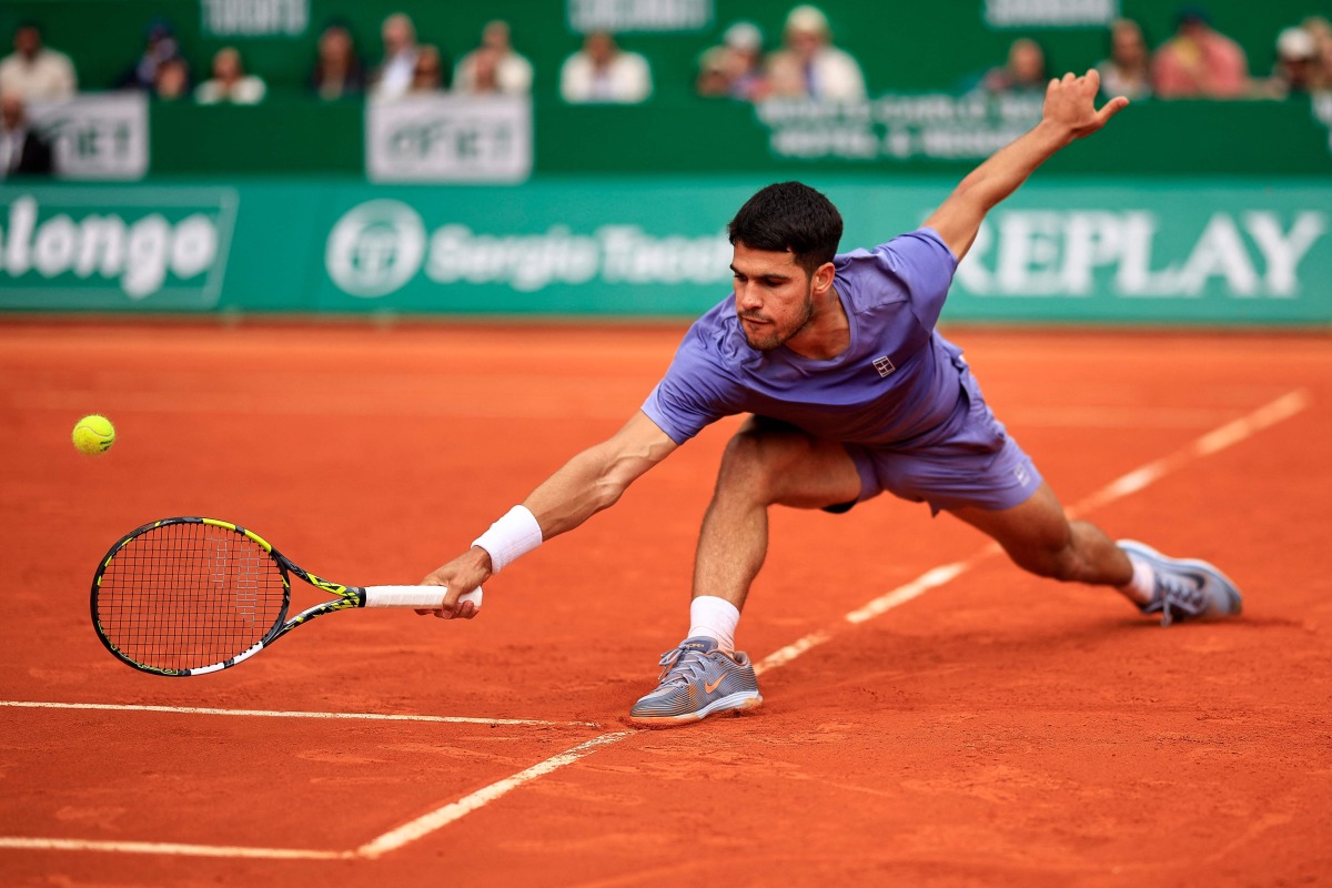 Spain's Carlos Alcaraz plays a backhand return to Spain's Alejandro Davidovich Fokina during the Monte Carlo ATP Masters Series Tournament semi-final tennis match at the Monte Carlo Country Club in Roquebrune-Cap-Martin on April 12, 2025. (Photo by Valery HACHE / AFP)

