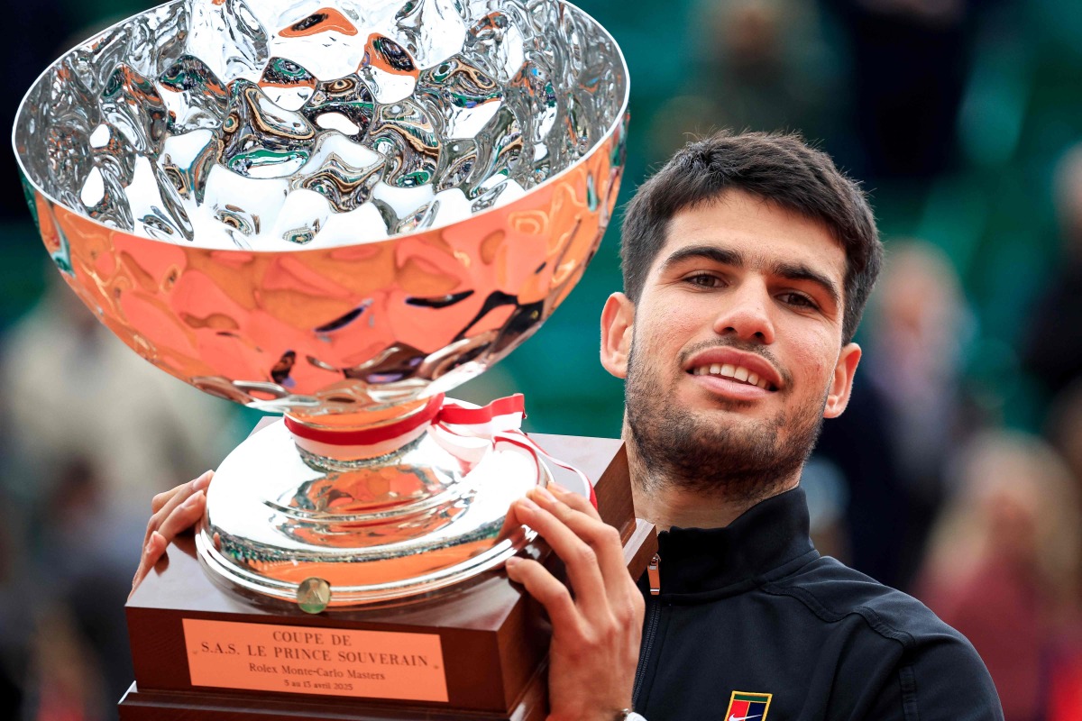 Spain's Carlos Alcaraz celebrates with the trophy after winning against Italy's Lorenzo Musetti the Monte Carlo ATP Masters Series Tournament final tennis match at the Monte Carlo Country Club in Roquebrune-Cap-Martin on April 13, 2025. (Photo by Valery HACHE / AFP)