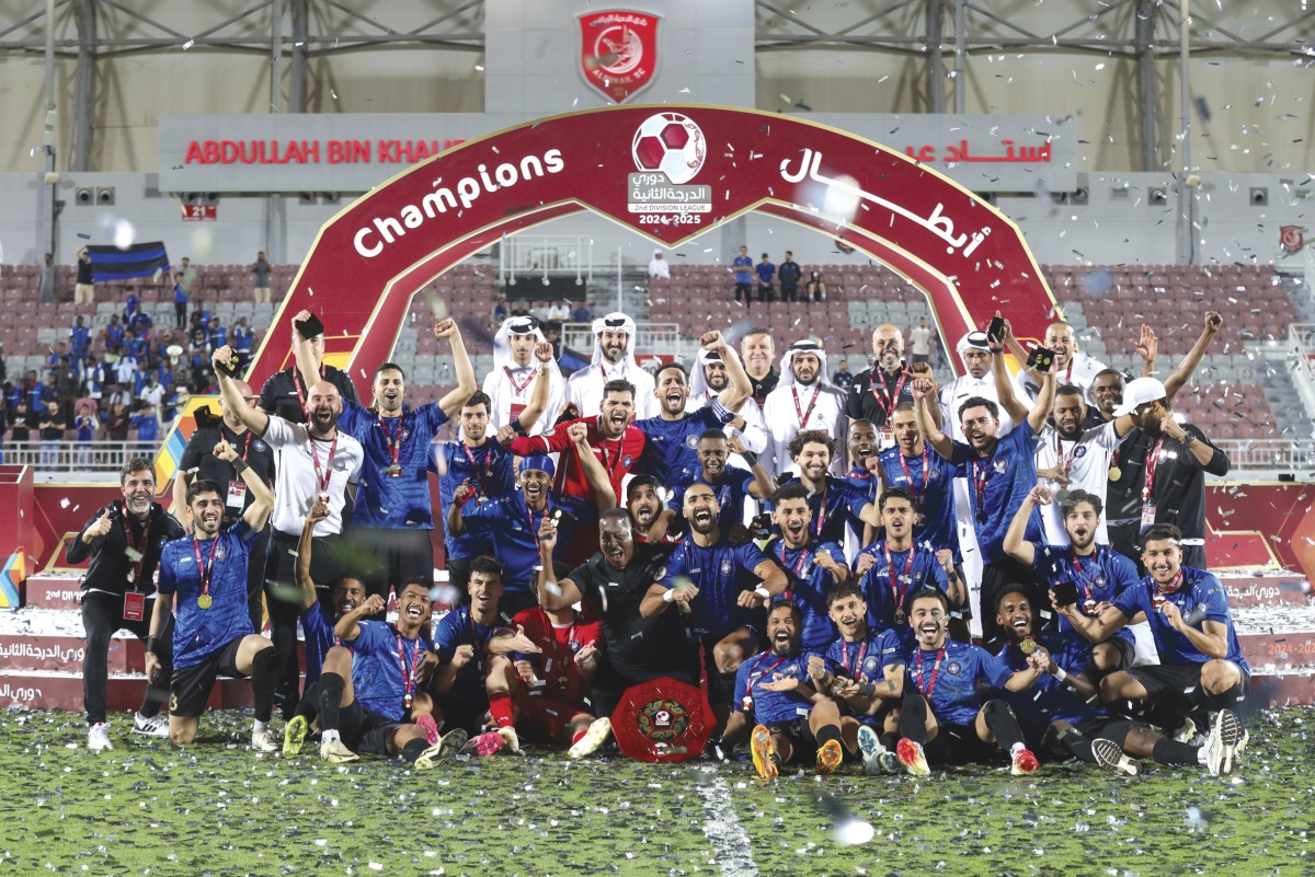 Al Sailiya's players and officials celebrate with the trophy.