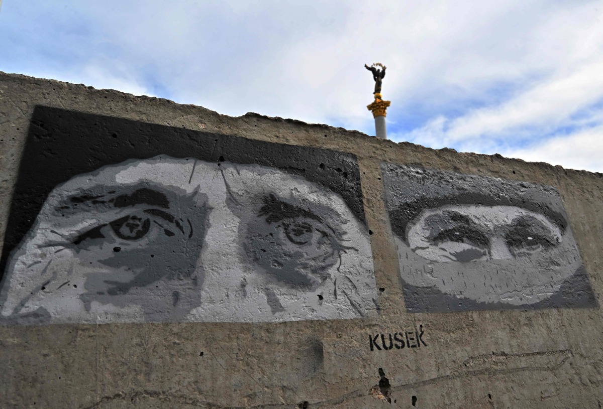 This photograph shows graffitis depicting fallen Ukrainian servicemen, painted by street artists at the Independence Square in Kyiv on April 19, 2025, amid the Russian invasion of Ukraine. Russian President Vladimir Putin on April 19 announced a surprise Easter truce in the conflict in Ukraine to last until midnight on April 20. (Photo by Sergei SUPINSKY / AFP)