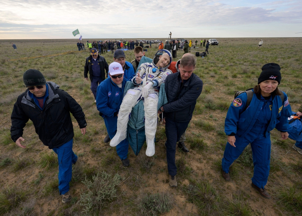 This handout picture courtesy of NASA shows NASA astronaut Don Pettit (C) being carried to a medical tent shortly after he landed in their Soyuz MS-26 spacecraft on April 20, 2025. (Photo by Bill Iingalls / NASA / AFP) 