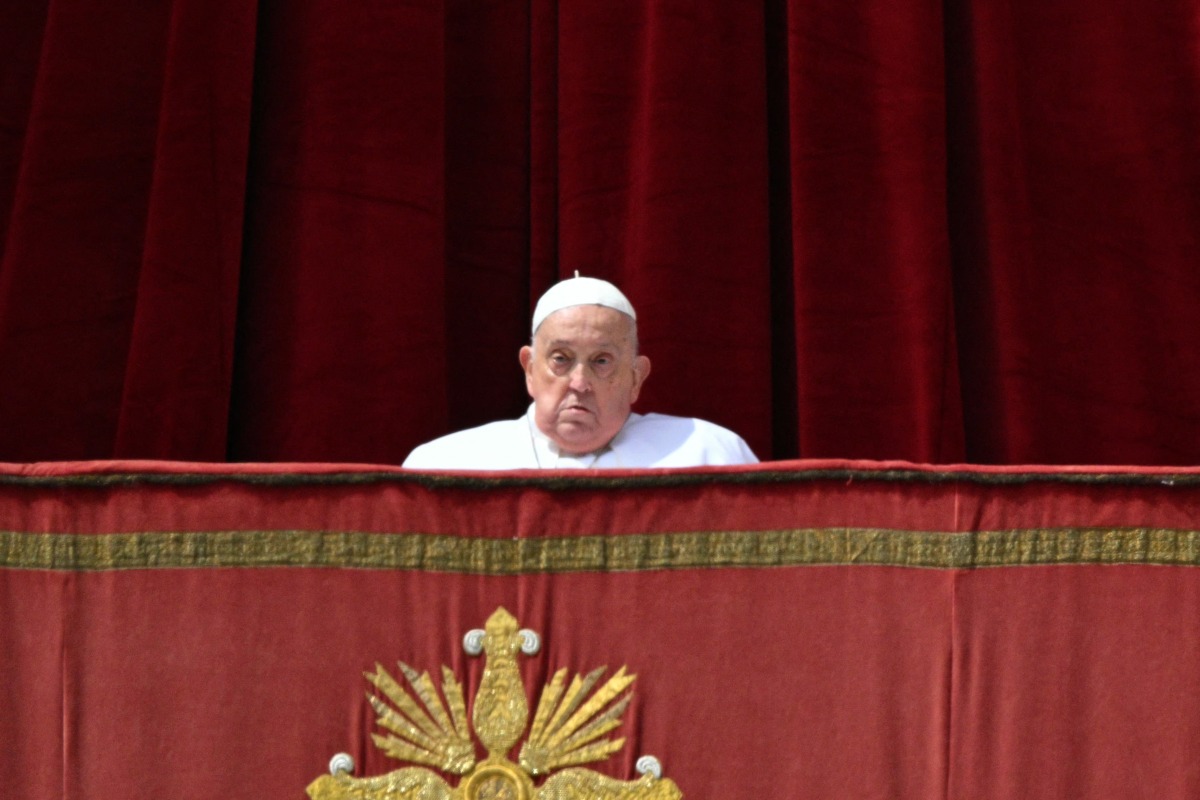 Pope Francis appears at the main balcony of St. Peter's basilica before the Urbi et Orbi message and blessing to the city and the world as part of Easter celebrations, at St Peter's square in the Vatican on April 20, 2025. (Photo by Andreas SOLARO / AFP)