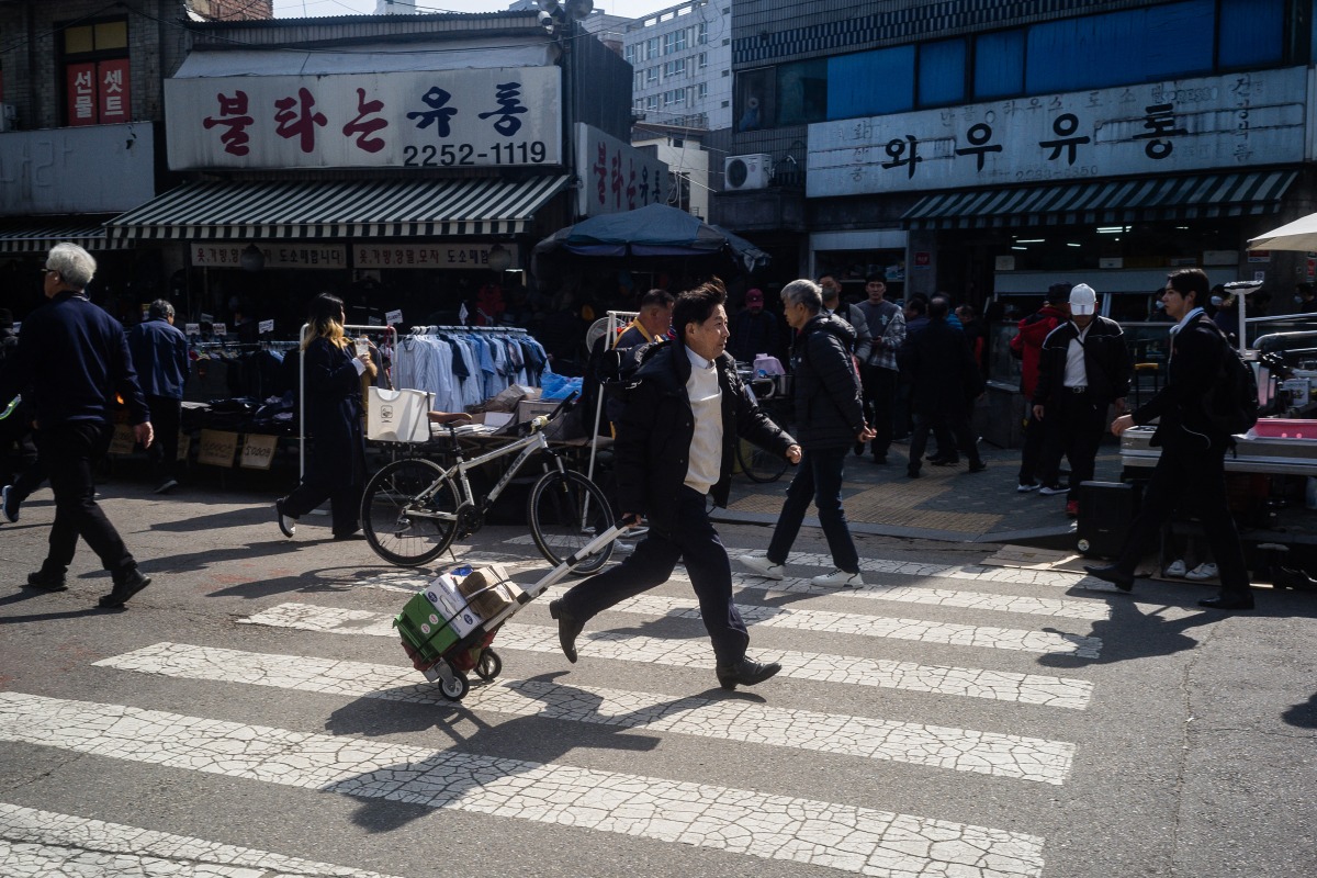 A man runs with a trolley at the Dongmyo Flea Market in Seoul on April 15, 2025. (Photo by ANTHONY WALLACE / AFP)
