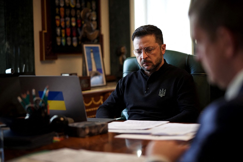 In this handout photograph taken and released on April 21, 2025, Ukraine's President Volodymyr Zelensky waits for a phone call with Britain's Prime Minister Keir Starmer as he sits at his desk in his office in Kyiv. (Photo by Handout / Ukrainian Presidential Press Service / AFP)
