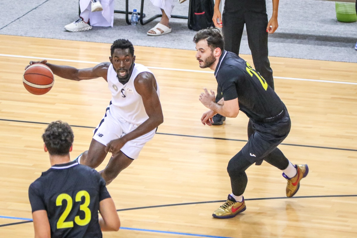 Al Sadd's Babacar Dieng dribbles past Qatar SC players.
