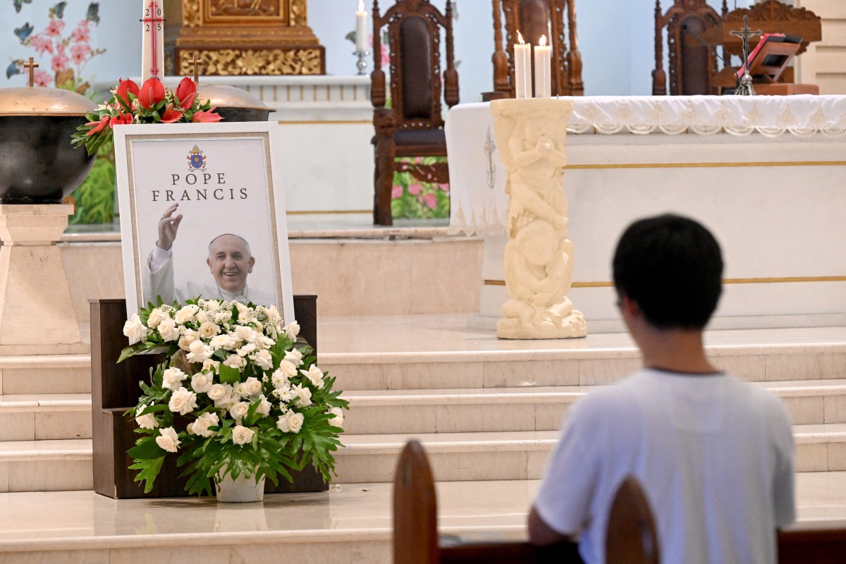 A portrait of Pope Francis is seen displayed at the altar of St. Francis Xavier Catholic Church in Kuta on Indonesia's resort island of Bali on April 22, 2025, a day after his death. Photo by SONNY TUMBELAKA / AFP.