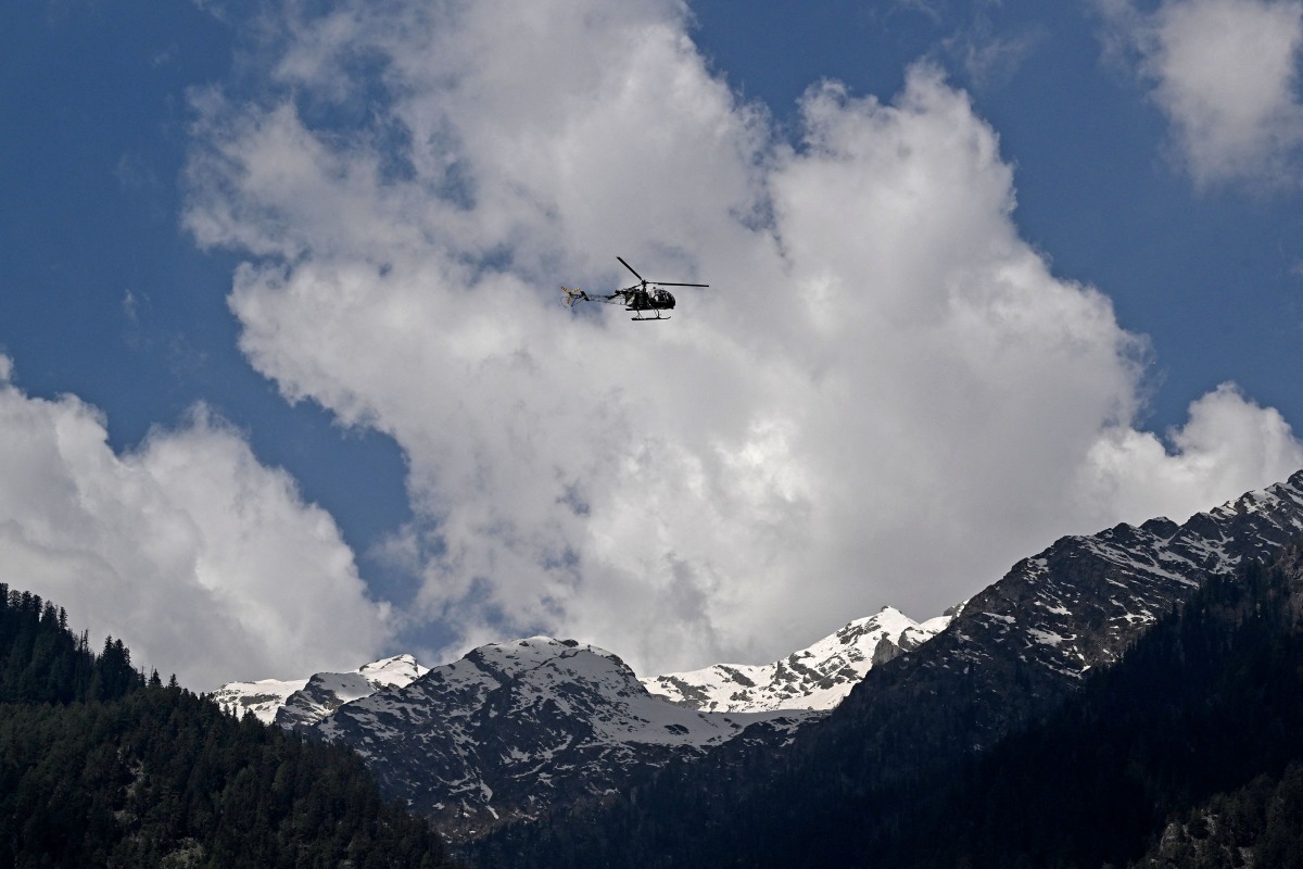 An Indian military helicopter is seen in flight as viewed from Baisaran, a day after tourist attack in Pahalgam, about 90 kms (55 miles) from Srinagar on April 23, 2025. (Photo by TAUSEEF MUSTAFA / AFP)
