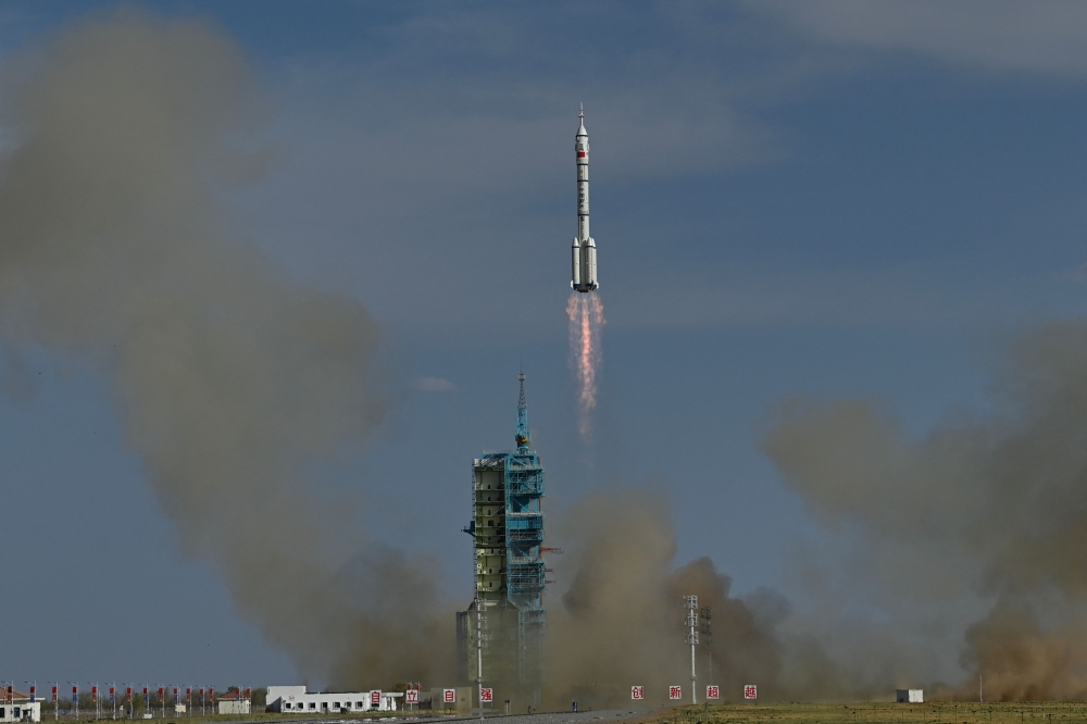 A Long March-2F carrier rocket, carrying the Shenzhou-20 spacecraft and a crew of three astronauts, lifts off from the Jiuquan Satellite Launch Centre in the Gobi desert, in northwest China on April 24, 2025. (Photo by Pedro Pardo / AFP)