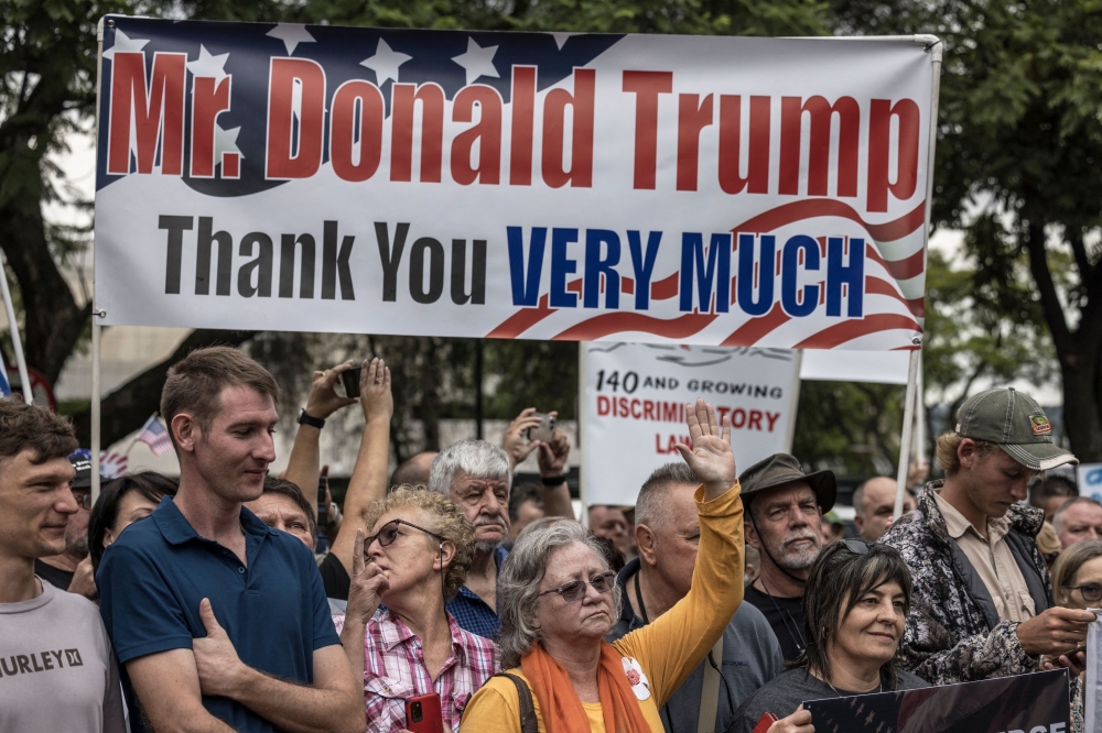 White South Africans supporting US President Donald Trump and South African and US tech billionaire Elon Musk gather in front of the US Embassy in Pretoria. (Photo by Marco Longari / AFP)
