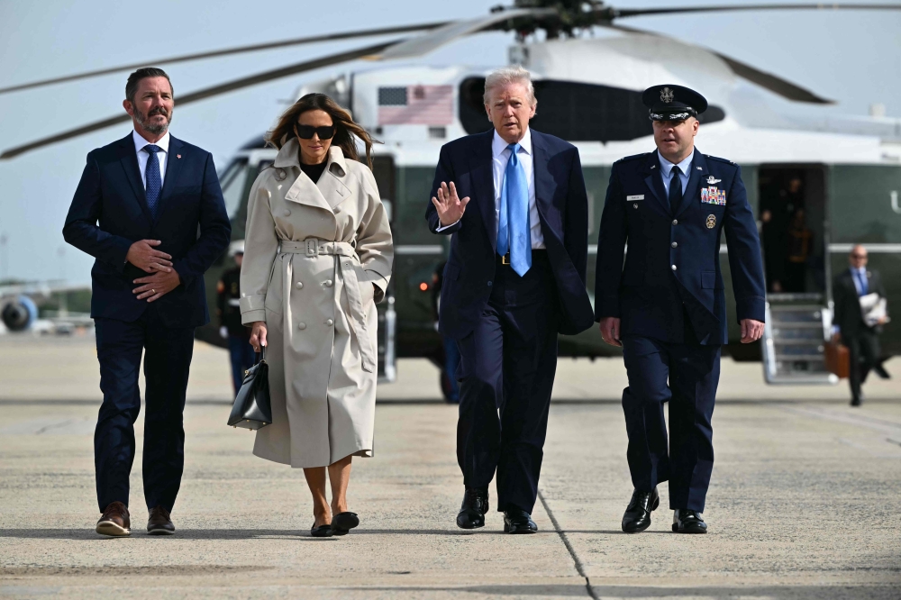 US President Donald Trump and First Lady Melania Trump make their way to board Air Force One before departing from Joint Base Andrews in Maryland on April 25, 2025. Trump is heading to Rome, Italy for the funeral for Pope Francis. (Photo by Mandel Ngan / AFP)
