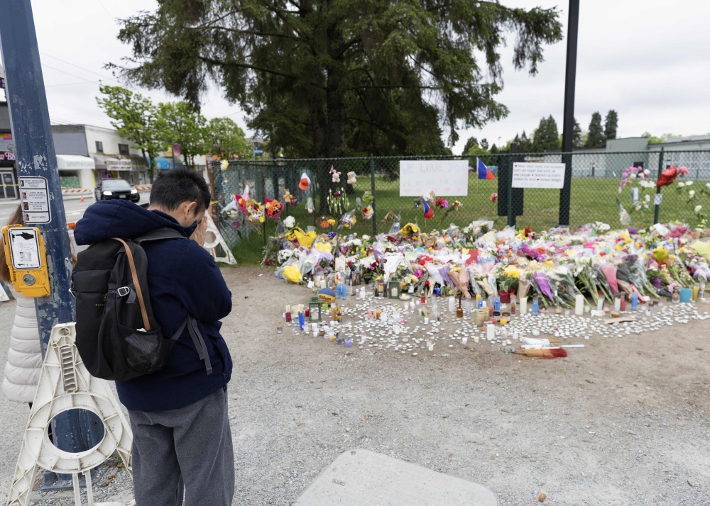 A person prays at a memorial near the scene where a car drove into a crowd during the Lapu Lapu Festival on April 28, 2025 in Vancouver, British Columbia. (Photo by Andrew Chin/Getty Images/AFP)
