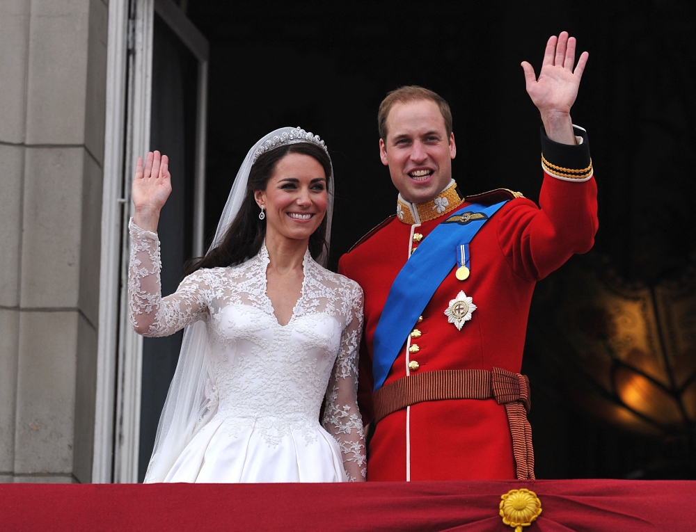 Britain's Prince William and his wife Kate, Duchess of Cambridge, wave to the crowd from the balcony of Buckingham Palace in London on April 29, 2011, following their wedding. (Photo by John Stillwell / POOL / AFP)
