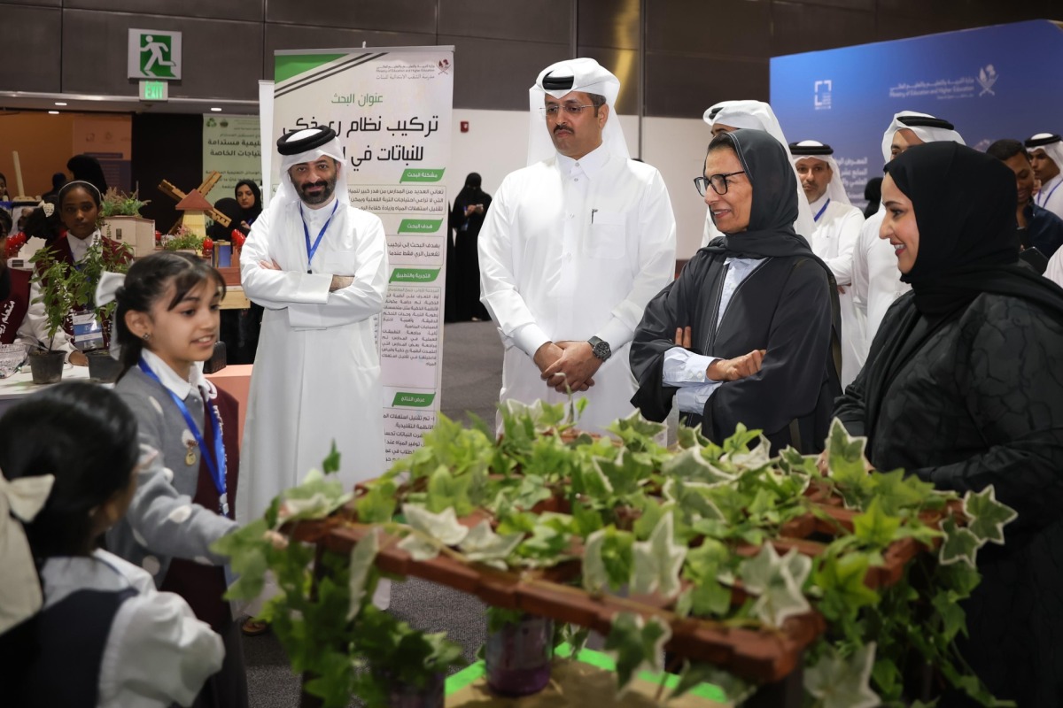Officials interacting with exhibitors during a tour. 