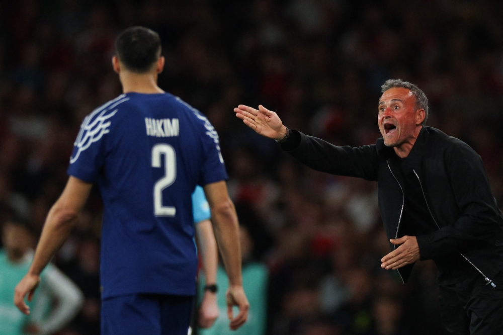 Paris Saint-Germain's Spanish head coach Luis Enrique (R) shouts instructions to Paris Saint-Germain's Moroccan defender #02 Achraf Hakimi (L) at the Emirates Stadium in north London, on April 29, 2025. (Photo by Adrian Dennis / AFP)