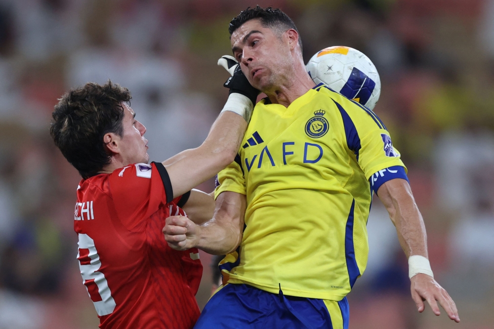 Kawasaki's Japanese goalkeeper #98 Louis Yamaguchi fights for the ball with Nassr's Portuguese forward #7 Cristiano Ronaldo during the AFC Champions League semi-final match between Saudi's Al-Nassr and Japan's Kawasaki at King Abdullah Sports City in Jeddah on April 30, 2025. (Photo by AFP)
