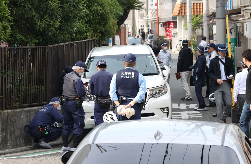 Police officers investigate the scene in Osaka's Nishinari district on May 1, 2025, after a man was arrested after allegedly ploughing his car into schoolchildren. (Photo by JIJI PRESS / AFP)