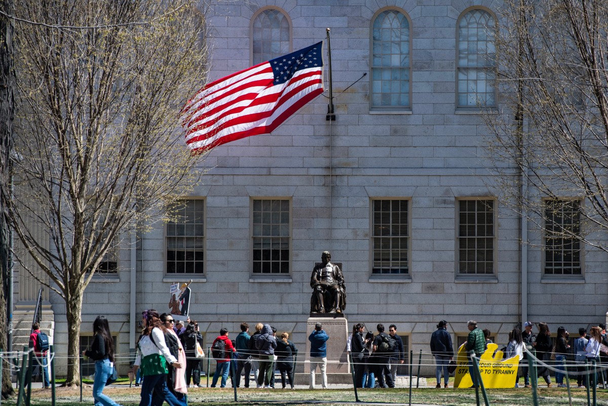 (Files) Demonstrators with signs stand around the John Harvard Statue in Harvard Yard following a rally against President Donald Trump’s attacks on Harvard University at Harvard University in Cambridge, Massachusetts on April 17, 2025. (Photo by Joseph Prezioso / AFP)