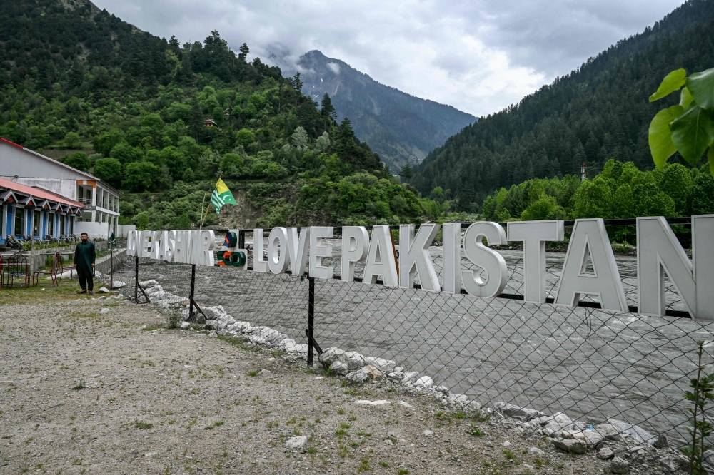 A guest house staff stands in an empty tourist place in Keran village on the Line of Control (LoC) in Neelum Valley, a district of Pakistan-administered Kashmir, on May 3, 2025. (Photo by Farooq Naeem / AFP)