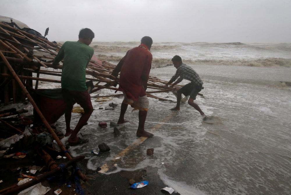 File photo for representational purposes only. Men remove bamboo rooftop of a stall damaged by heavy winds at a shore ahead of Cyclone Yaas in Bichitrapur in Balasore district in the eastern state of Odisha India, May 26, 2021. REUTERS/Rupak De Chowdhuri

