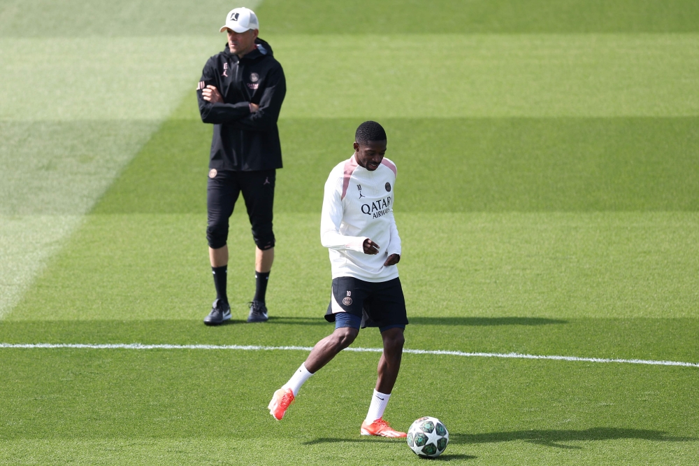 Paris Saint-Germain's French forward #10 Ousmane Dembele, next to Paris Saint-Germain's Spanish headcoach Luis Enrique (L), takes part in a training session on the eve of their second leg semi-final UEFA Champions League match against Arsenal, at the club's training ground in Poissy, west of Paris, on May 6, 2025. (Photo by Franck Fife / AFP)