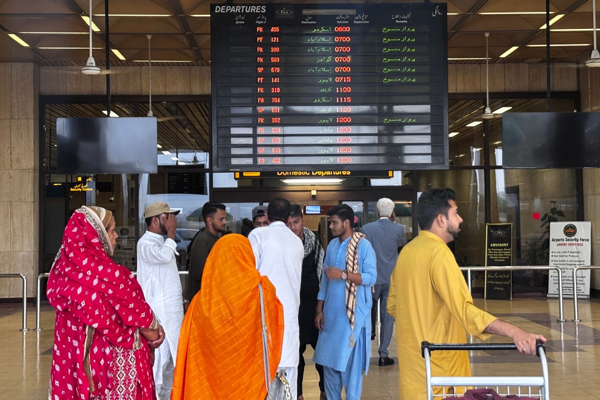 Passengers wait at Jinnah International airport after all domestic and international flights were cancelled in Karachi on May 7, 2025. Photo by Asif HASSAN / AFP