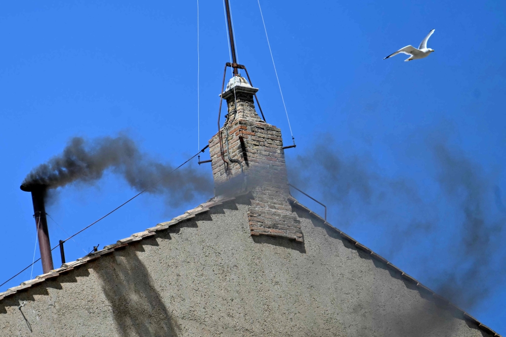 This photograph shows black smoke rising from the chimney of the Sistine Chapel signalling that cardinals failed to elect a new pope during their conclave in the Vatican on May 8, 2025. (Photo by Alberto PIZZOLI / AFP)