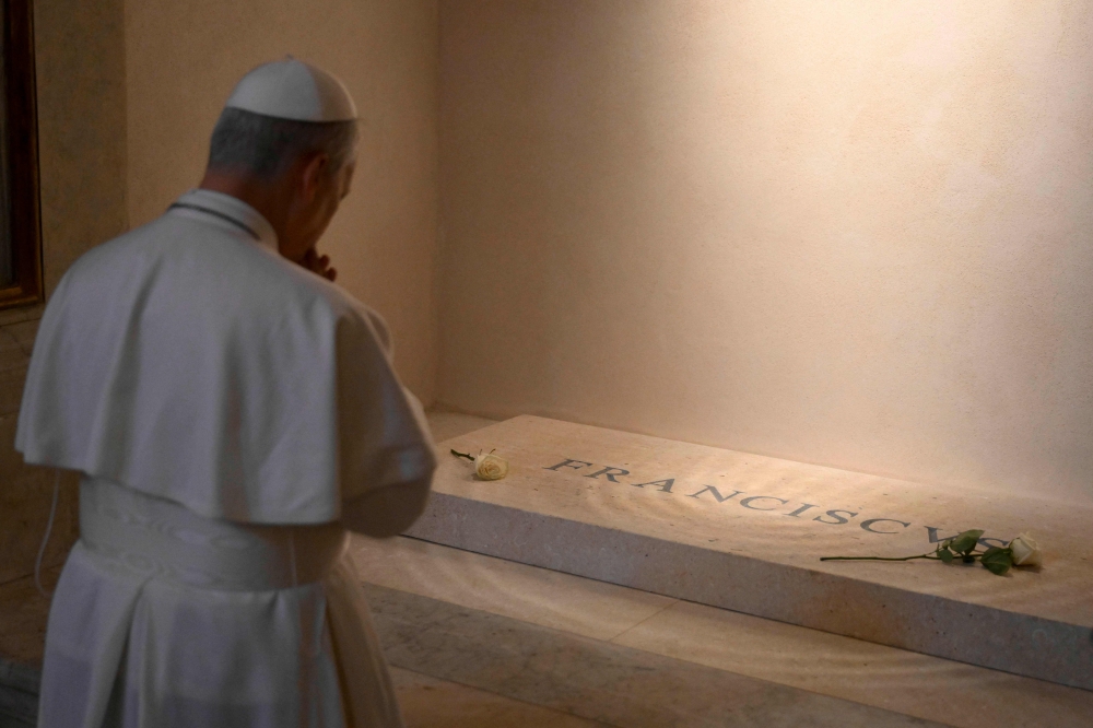 This photo taken and released on May 10, 2025 by The Vatican Media shows Pope Leo XIV paying his respects to late Pope Francis in front of his tomb at Santa Maria Maggiore Basilica in Rome. (Photo by Handout / Vatican Media / AFP)