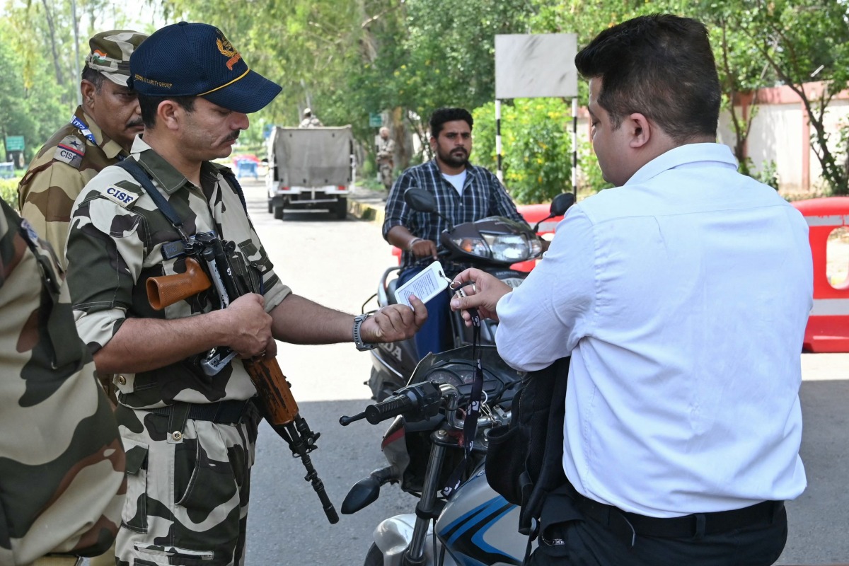 Indian Central Industrial Security Forces (CISF) personnel check identity card of Airport staff at the entrance road of the Shri Guru Ram Das Ji International Airport on the outskirts of Amritsar on May 12, 2025. (Photo by Narinder NANU / AFP)