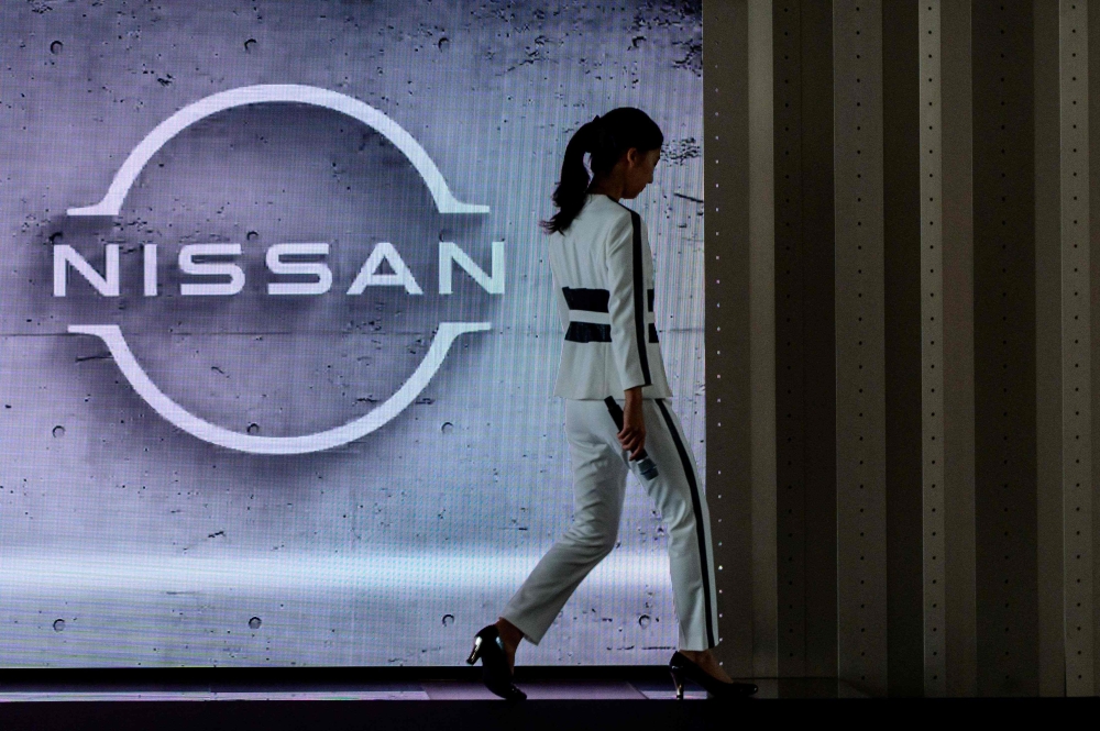 (Files) This file photo taken on July 28, 2020 shows a staff member walking off stage at the end of a presentation in the showroom at Nissan's global headquarters in Yokohama. (Photo by Philip Fong / AFP)
