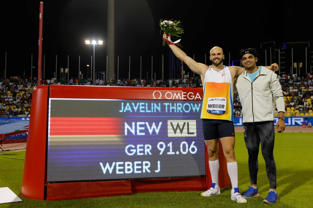 Germany's Julian Weber celebrates his world leading score with India's Neeraj Chopra (R) after the men's Javelin throw final during the IAAF Diamond League competition at the Suheim Bin Hamad Stadium in Doha on May 16, 2025. (Photo by Karim Jaafar / AFP)