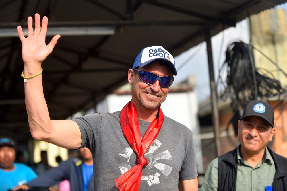 (Files) British mountaineer Kenton Cool (L) who summitted Mount Everest (8,849-metre) for the 17th time waves upon arriving at the airport in Kathmandu on May 19, 2023. (Photo by Nisha Bhandari / AFP)