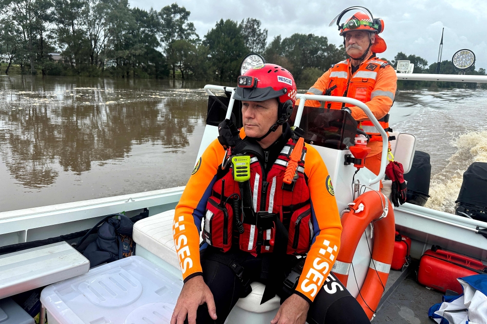 This handout photo taken and released on May 21, 2025 by the New South Wales State Emergency Service (NSWSES) shows SES officials on patrol in flood-affected areas in and around Taree. (Photo by Handout / New South Wales State Emergency Service / AFP) 