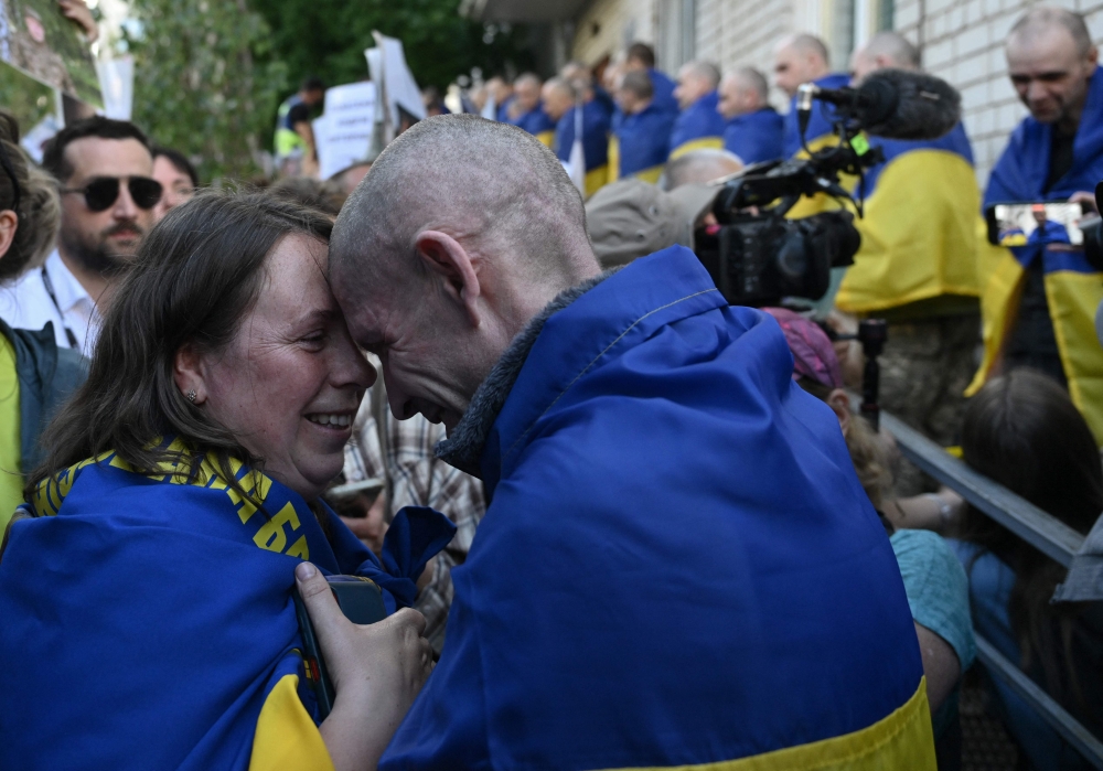 Ukrainian POW Oleksandr (right) embraces his wife Olena upon arrival after a prisoner exchange in the Chernihiv Region on May 23, 2025. (Photo by Genya Savilov / AFP)