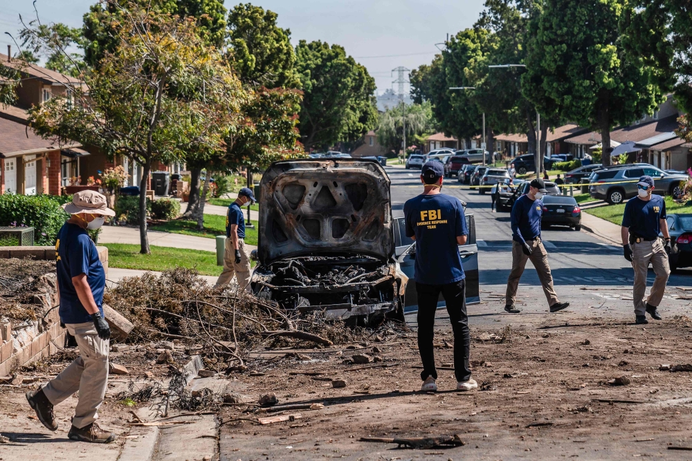 Members of the the Federal Bureau of Investigation (FBI) walk around the crash site after a small plane crashed into a neighborhood, setting homes and vehicles on fire on May 22, 2025 in San Diego, California. Ariana Drehsler/Getty Images/AFP 