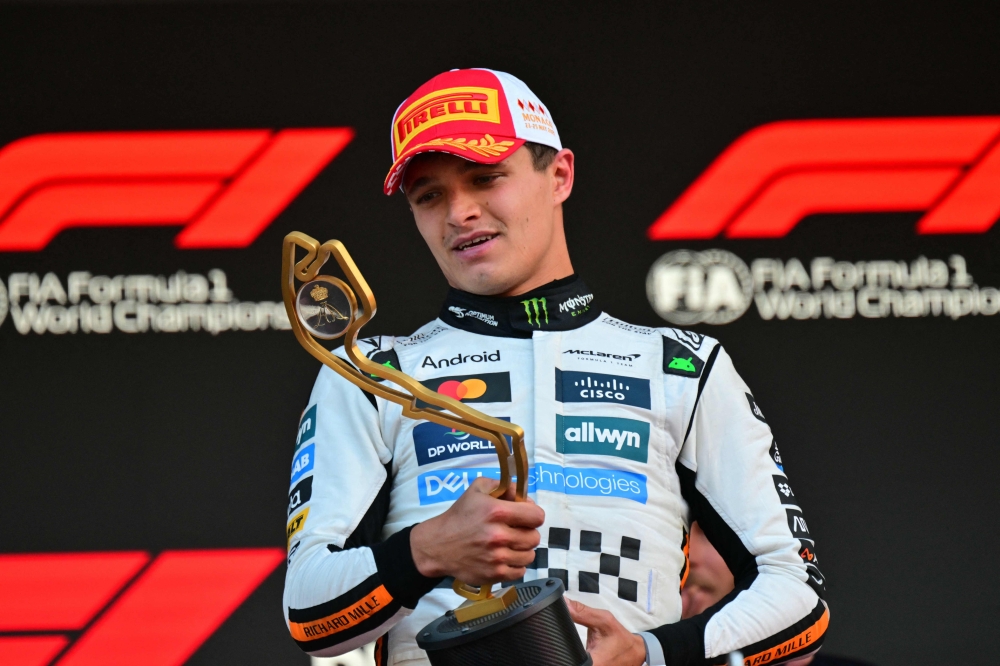 McLaren's British driver Lando Norris looks at the trophy on the podium after winning the Formula One Monaco Grand Prix at the Circuit de Monaco, on May 25, 2025. (Photo by Andrej Isakovic / AFP)