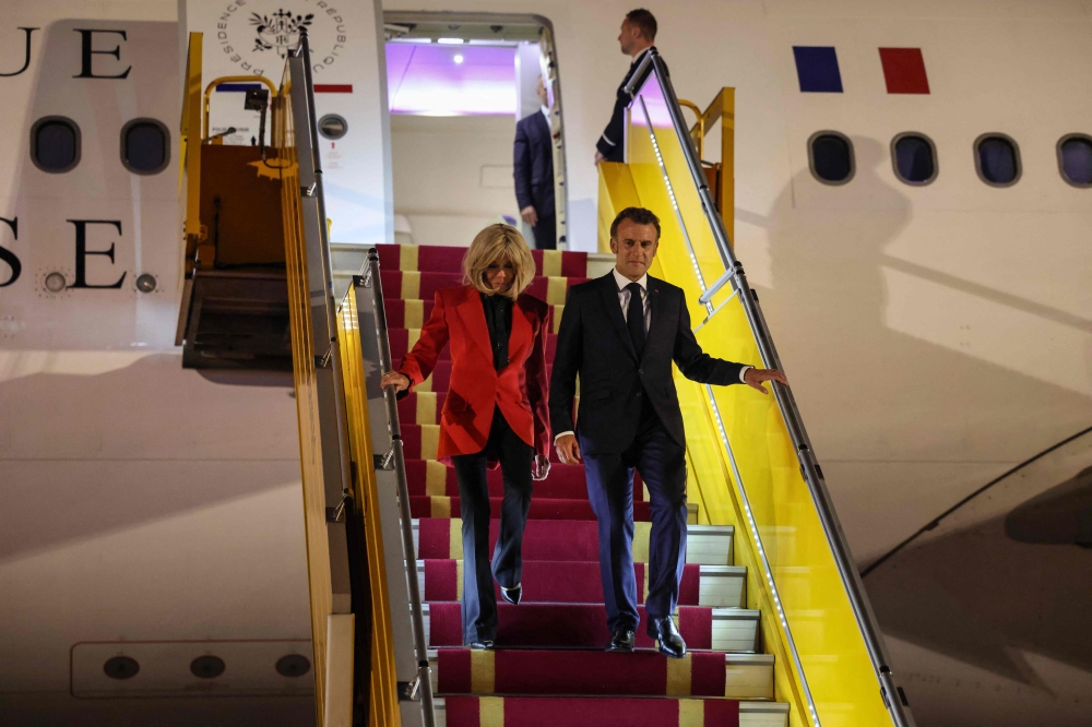 France's President Emmanuel Macron and his wife Brigitte Macron disembark from the plane upon their arrival at Noi Bai International Airport in Hanoi on May 25, 2025.  (Photo by Ludovic Marin / AFP)