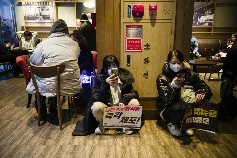 People visit a Starbucks cafe after a political protest in Seoul on December 6.  (Photo by Jintak Han/The Washington Post)
