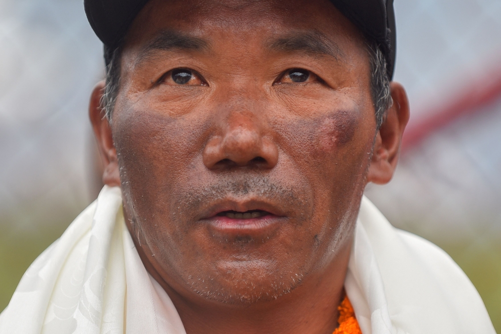 (Files) Nepali guide Kami Rita Sherpa who reached the top of Mount Everest on May 23, 2023, for a record 28th time looks on after his arrival at the Tribhuvan airport in Kathmandu on May 25, 2023. (Photo by Nisha Bhandari / AFP)
