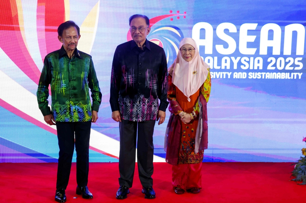 Malaysia's Prime Minister Anwar Ibrahim (C) with wife Wan Azizah Wan Ismail (R) poses alongside Sultan of Brunei Hassanal Bolkiah before a gala dinner during the 46th Association of Southeast Asian Nations (ASEAN) Summit in Kuala Lumpur on May 26, 2025. (Photo by Fazry Ismail / POOL / AFP)