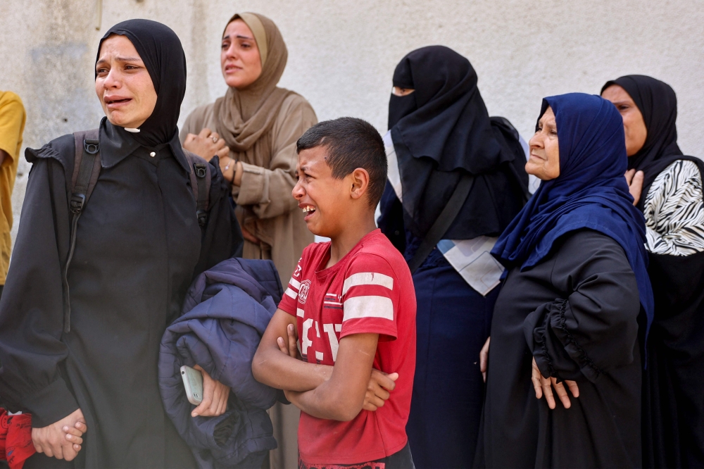 Women mourn relatives killed in an Israeli strike, at Al-Shifa hospital in Gaza City on May 26, 2025. (Photo by Omar Al-Qattaa / AFP)