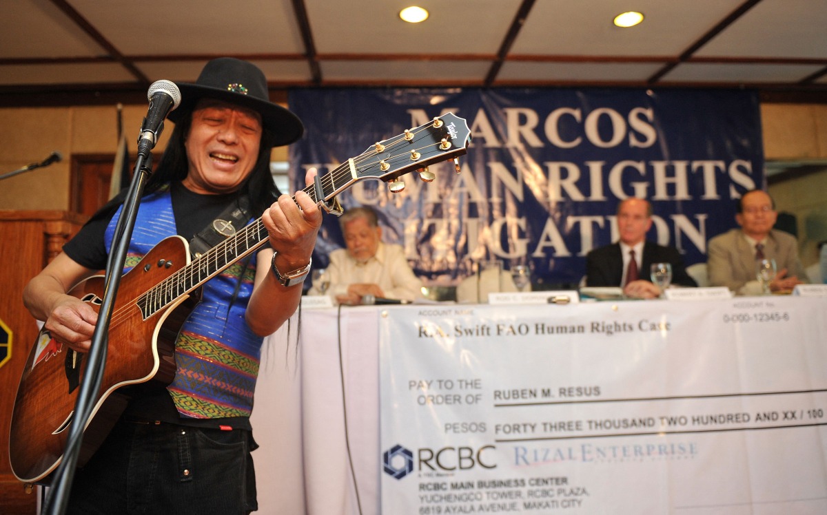(FILES) Freddie Aguilar, a folk singer who took part in street protests under the late Philippine president Ferdinand Marcos, performs during a ceremony handing out compensation cheques to victims of human rights during the Marcos dictatorship, in Manila on February 28, 2011. (Photo by Ted ALJIBE / AFP)
