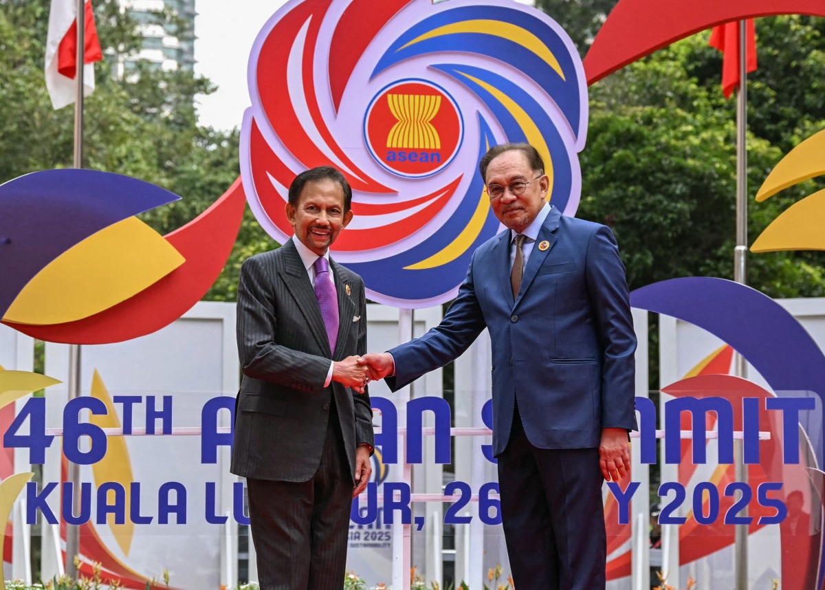 Malaysia's Prime Minister Anwar Ibrahim (R) greets Brunei's Sultan Hassanal Bolkiah before the plenary session at the 46th Association of Southeast Asian Nations (ASEAN) Summit in Kuala Lumpur on May 26, 2025. (Photo by MOHD RASFAN / POOL / AFP)
