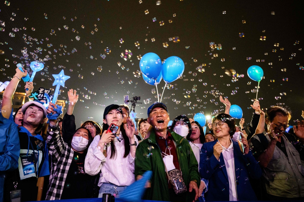 South Koreans cheer during final election campaign event ahead of the upcoming June 3 presidential election in Seoul on June 2, 2025. (Photo by Anthony Wallace / AFP)