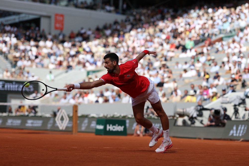 Serbia's Novak Djokovic plays a backhand return to Britain's Cameron Norrie during their men's singles match on day 9 of the French Open tennis tournament on Court Philippe-Chatrier at the Roland-Garros Complex in Paris on June 2, 2025. (Photo by Alain Jocard / AFP)
