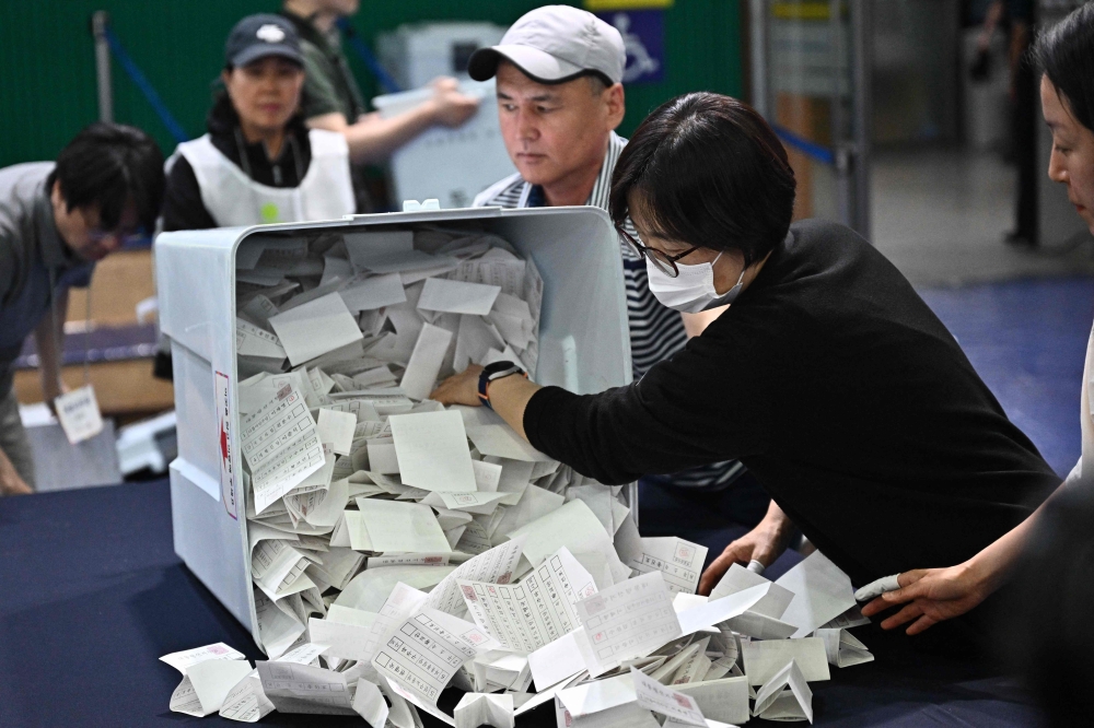 Election officials unload a ballot box at a counting station in Seoul on June 3, 2025. (Photo by Pedro Pardo / AFP)